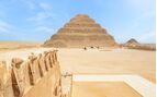 View of the pyramids with people riding camels in the background