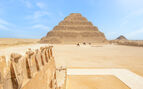 View of the pyramids with people riding camels in the background