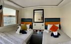 photo of two single bed inside a boat cabin with towel swans on the bed